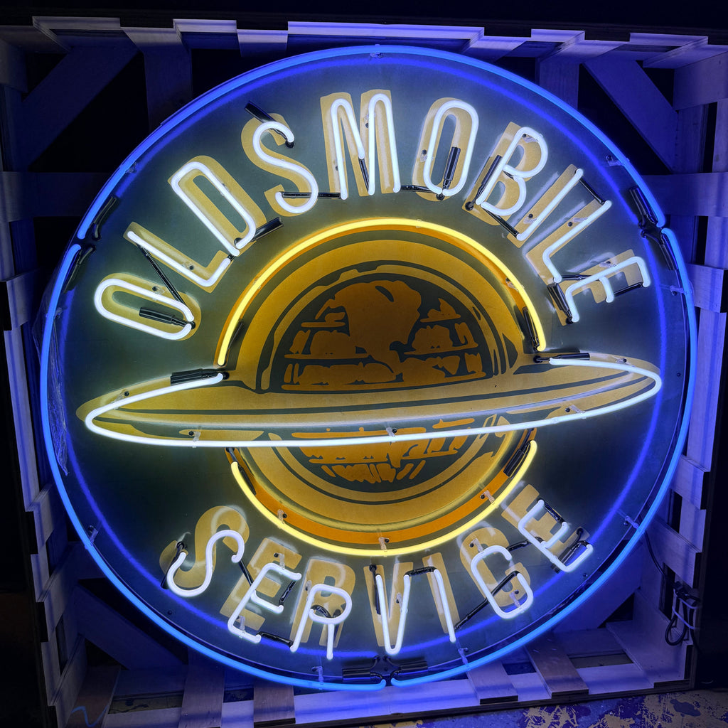Neon sign for Oldsmobile service with blue and yellow colors.